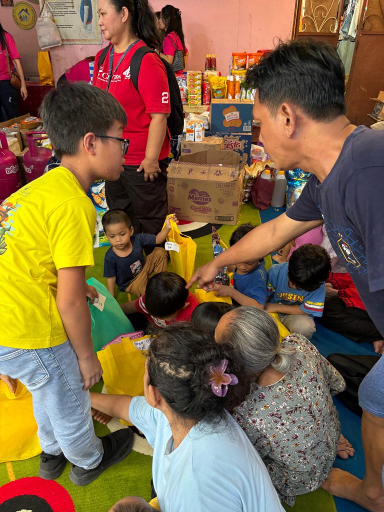 Penyerahan bantuan sembako oleh siswa Sekolah Citra Kasih Samarinda
